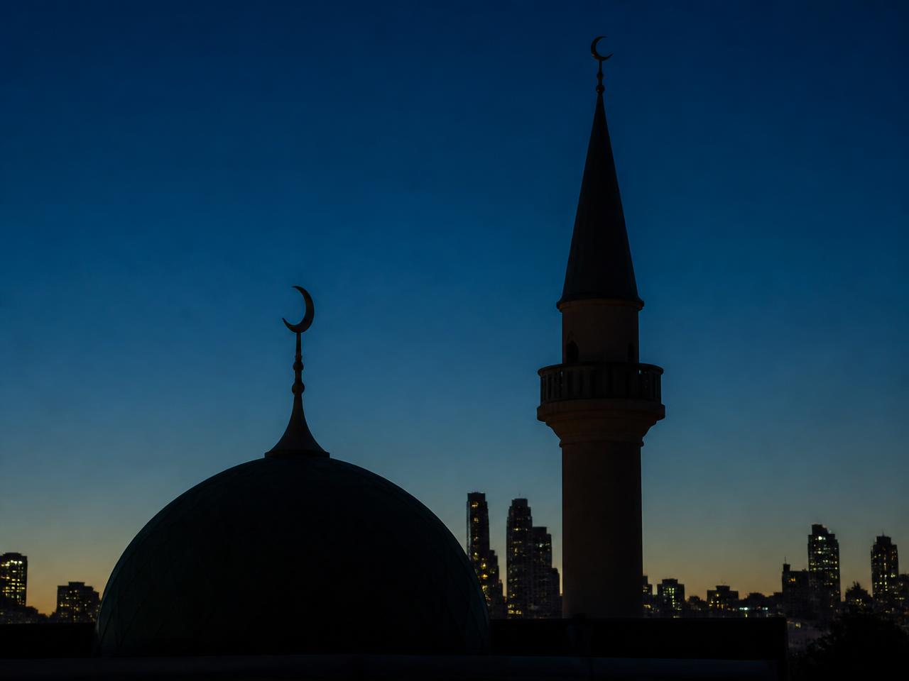 A mosque dome and minaret at dusk